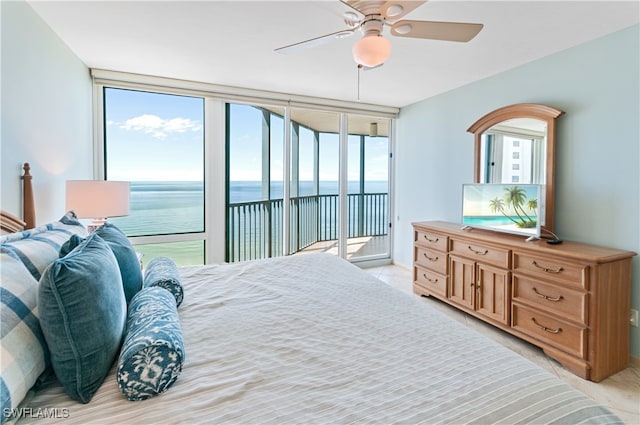 bedroom with access to outside, multiple windows, a water view, and ceiling fan