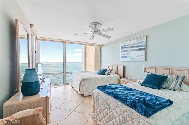 bedroom with expansive windows, light tile patterned floors, and ceiling fan