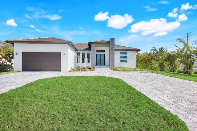 view of front of home featuring a front yard and a garage