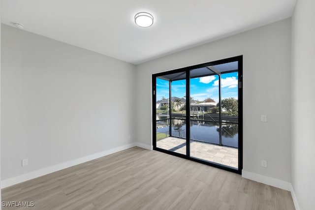 empty room featuring light hardwood / wood-style flooring and a water view