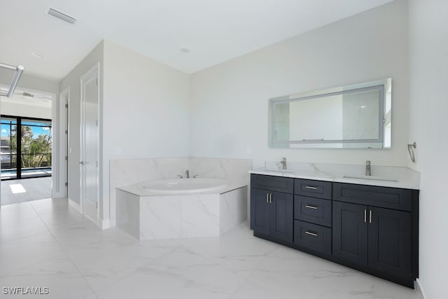 bathroom with vanity and tiled tub