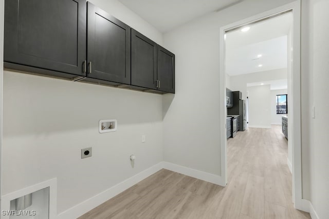 washroom with hookup for a gas dryer, electric dryer hookup, hookup for a washing machine, cabinets, and light hardwood / wood-style floors