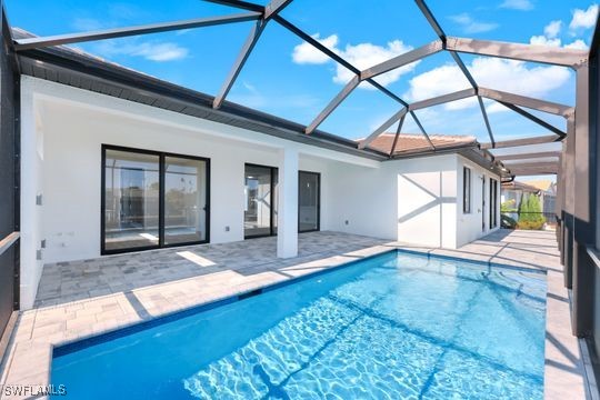 view of swimming pool with a patio area and glass enclosure