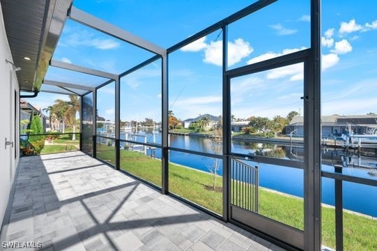 unfurnished sunroom featuring a water view