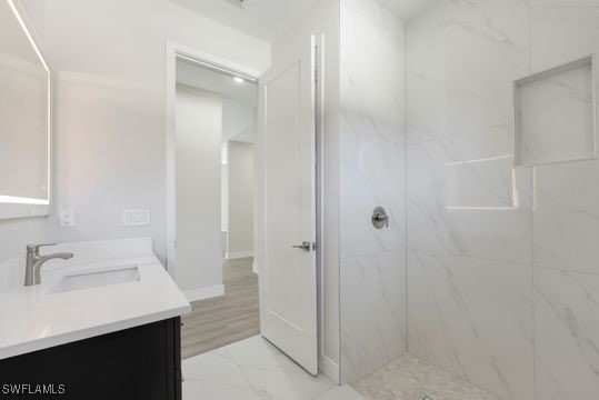 bathroom featuring vanity and tiled shower