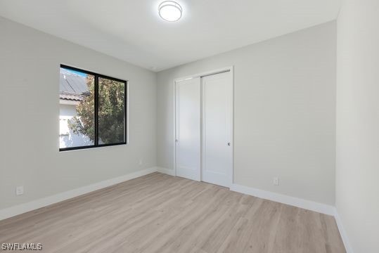 unfurnished bedroom with a closet and light hardwood / wood-style flooring