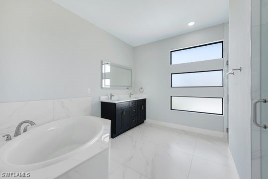 bathroom with vanity and shower with separate bathtub