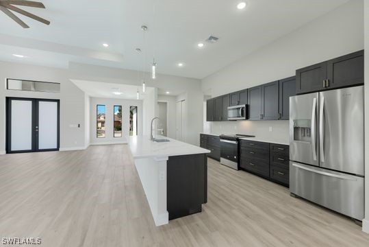 198 Gulfview Rd, Punta Gorda, FL 33950 - kitchen with stainless steel appliances, light wood-style floors, light countertops, hanging light fixtures, and recessed lighting