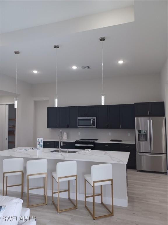 198 Gulfview Rd, Punta Gorda, FL 33950 - kitchen with stainless steel appliances, a kitchen breakfast bar, dark cabinets, light stone countertops, and pendant lighting