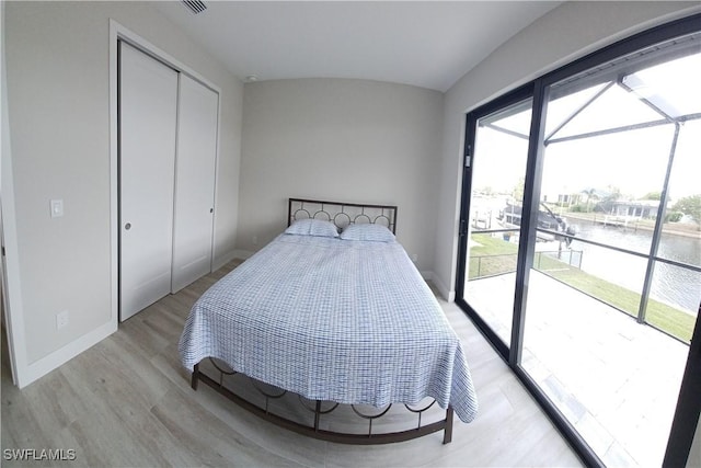 198 Gulfview Rd, Punta Gorda, FL 33950 - bedroom featuring a water view, access to exterior, light wood-type flooring, multiple windows, and vaulted ceiling