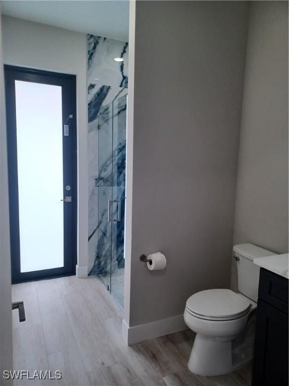 198 Gulfview Rd, Punta Gorda, FL 33950 - bathroom featuring a marble finish shower, vanity, wood finished floors, and plenty of natural light