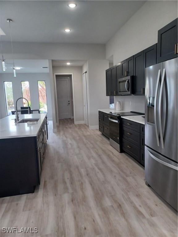 198 Gulfview Rd, Punta Gorda, FL 33950 - kitchen featuring stainless steel appliances, dark cabinets, light wood-type flooring, light countertops, and recessed lighting