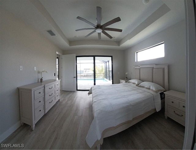 198 Gulfview Rd, Punta Gorda, FL 33950 - bedroom featuring a tray ceiling, access to outside, light wood-style floors, and ceiling fan
