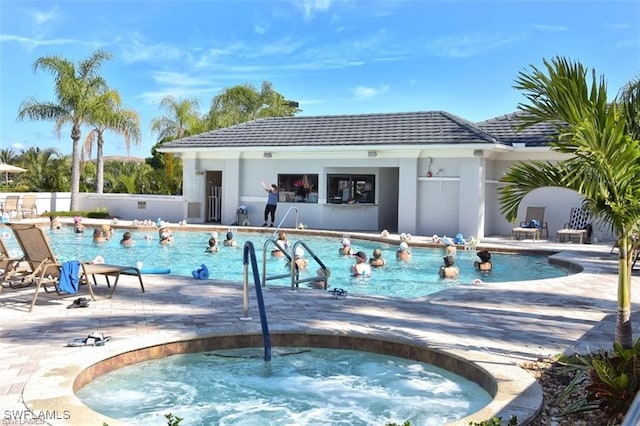 view of pool with a hot tub and a patio area