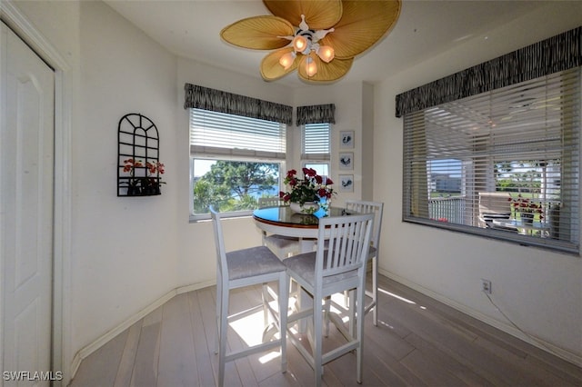 dining area with ceiling fan and wood-type flooring