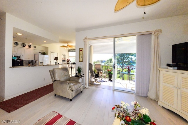 living room featuring light hardwood / wood-style flooring and ceiling fan