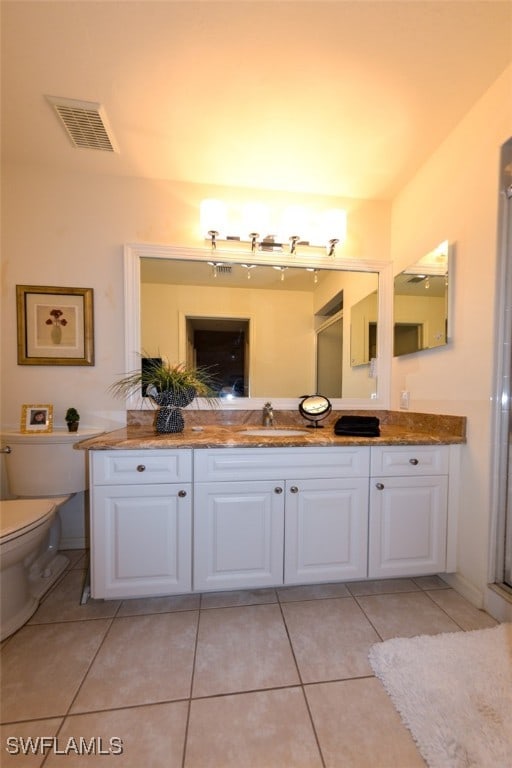 bathroom with vanity, toilet, and tile patterned floors