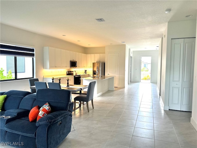 tiled living room with a textured ceiling and sink