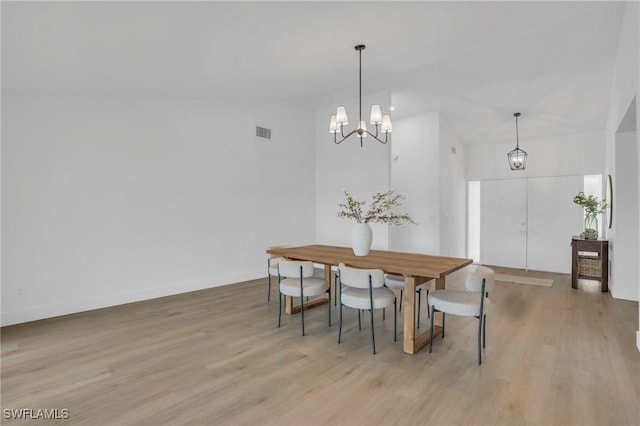 dining area with a chandelier, visible vents, and wood finished floors