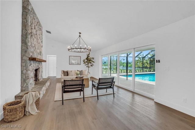 interior space with baseboards, visible vents, wood finished floors, a fireplace, and high vaulted ceiling