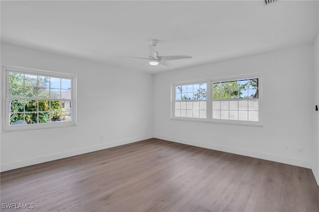 spare room featuring ceiling fan, plenty of natural light, and hardwood / wood-style floors