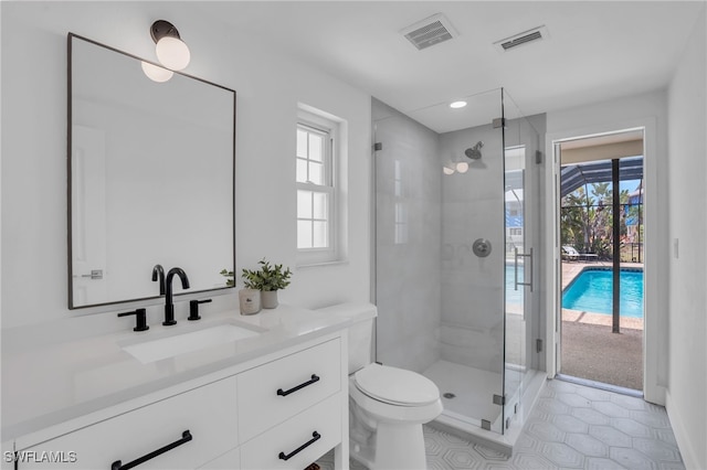 bathroom featuring vanity, a healthy amount of sunlight, toilet, and walk in shower