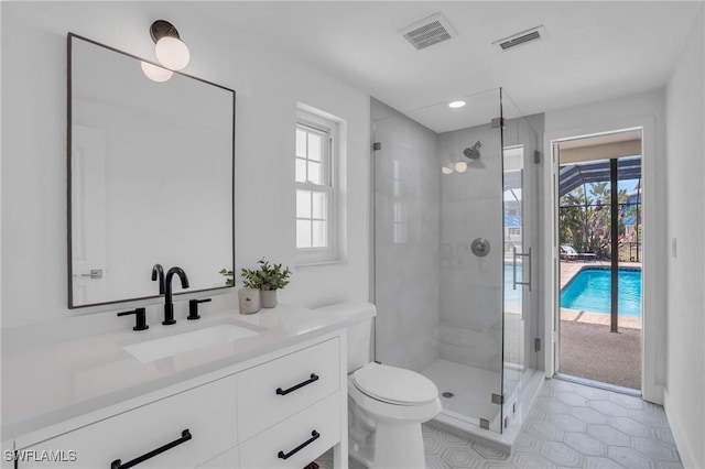 bathroom with toilet, a shower stall, visible vents, and vanity