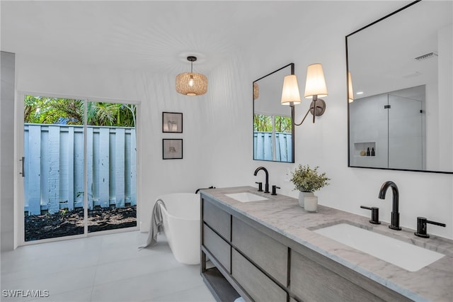 bathroom featuring tile patterned floors, a bathtub, and vanity