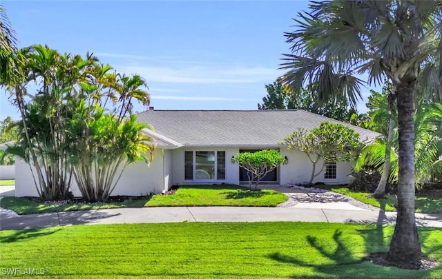 view of front of house with a front yard, driveway, and stucco siding