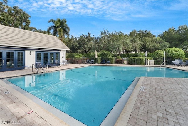 view of swimming pool with a patio and french doors