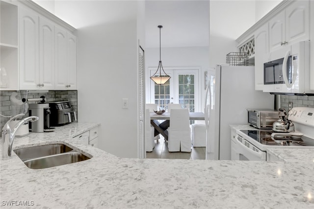 kitchen with backsplash, sink, white cabinets, light stone counters, and white appliances