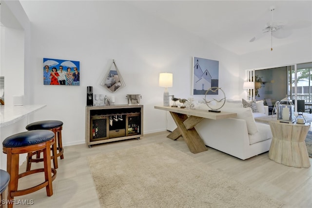 living room with light hardwood / wood-style floors, lofted ceiling, and ceiling fan