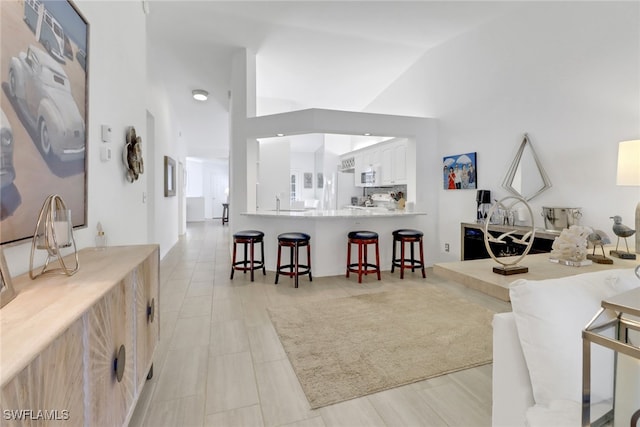 tiled living room featuring high vaulted ceiling