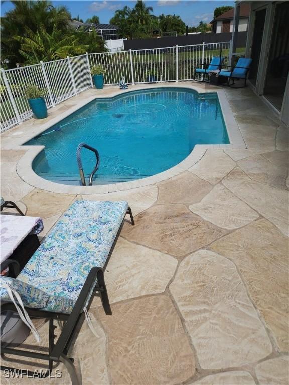 view of swimming pool featuring a patio, fence, and a fenced in pool