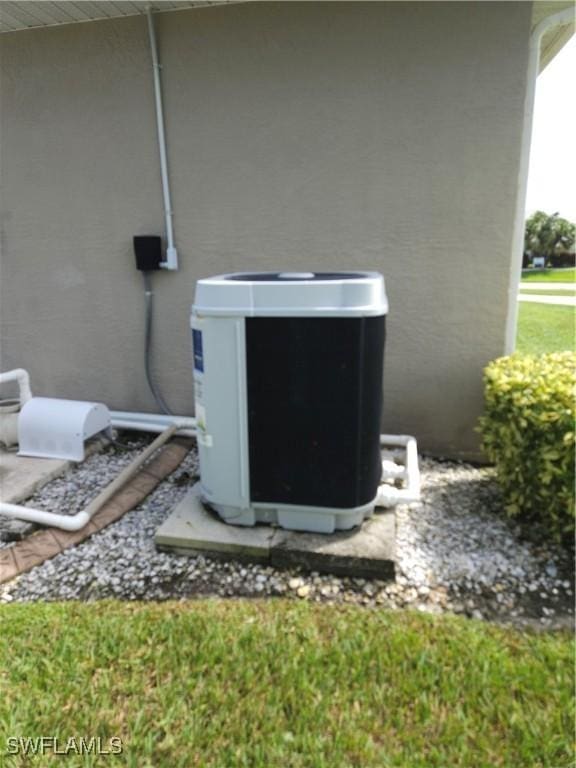 exterior details featuring central AC unit and stucco siding