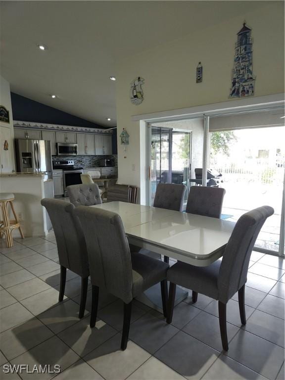 dining space with lofted ceiling, light tile patterned flooring, and recessed lighting