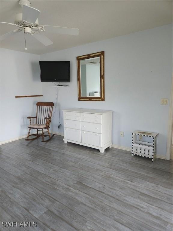 unfurnished room with ceiling fan, wood finished floors, and baseboards