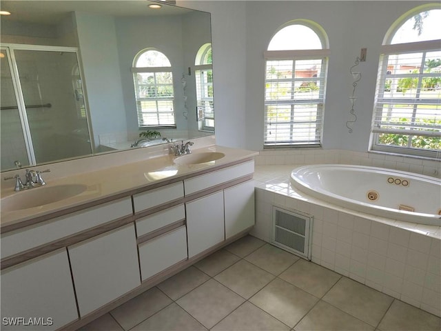 bathroom featuring tile patterned floors, a stall shower, a sink, and a jetted tub