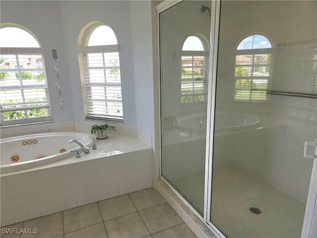 bathroom with a jetted tub, a shower stall, and tile patterned floors