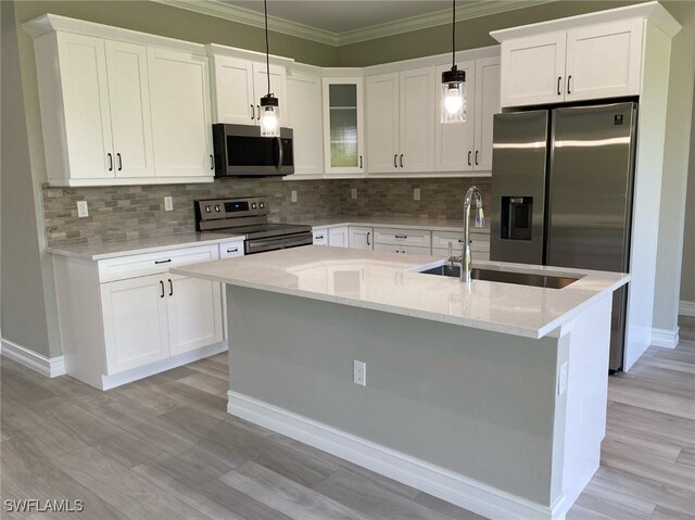 kitchen featuring white cabinetry, appliances with stainless steel finishes, hanging light fixtures, and sink