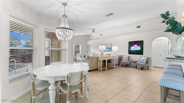 tiled dining area with ceiling fan with notable chandelier