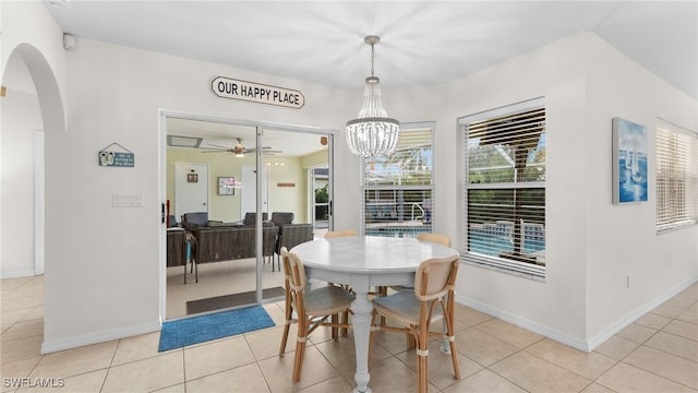 dining space featuring light tile patterned floors and ceiling fan with notable chandelier