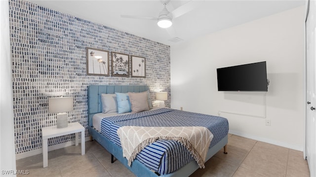 bedroom with tile patterned flooring, ceiling fan, and tile walls