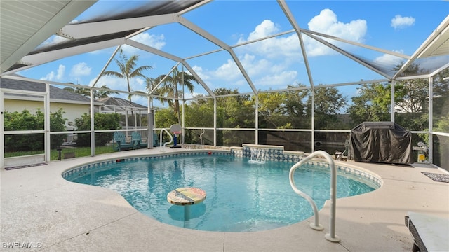 view of swimming pool featuring a patio, glass enclosure, pool water feature, and a grill