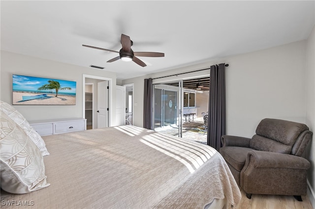 bedroom with light hardwood / wood-style floors, ceiling fan, a walk in closet, and access to outside