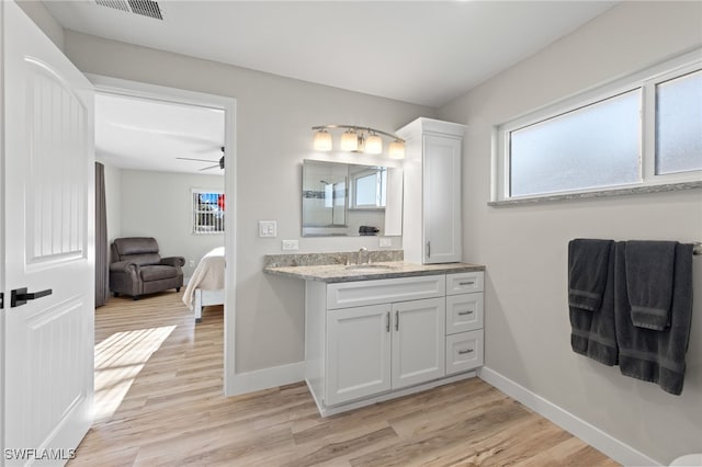 bathroom featuring a healthy amount of sunlight, vanity, hardwood / wood-style floors, and ceiling fan