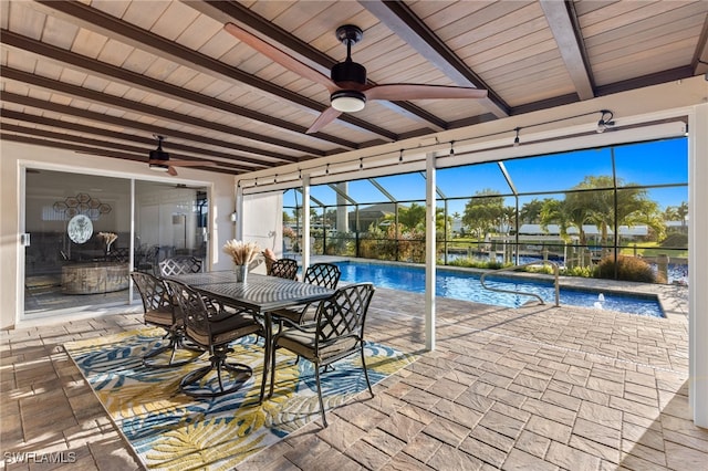 view of swimming pool featuring a patio, glass enclosure, and ceiling fan