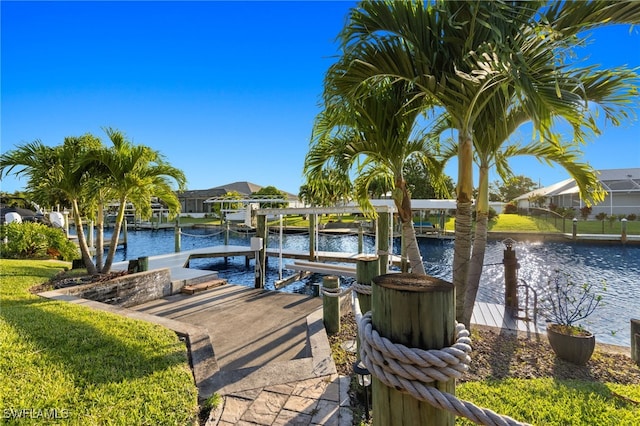 view of dock with glass enclosure, a water view, and a lawn