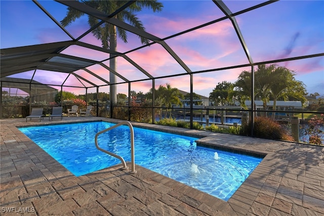 pool at dusk with a water view, glass enclosure, and a patio