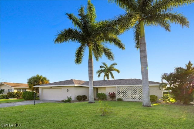 single story home with a garage and a front lawn